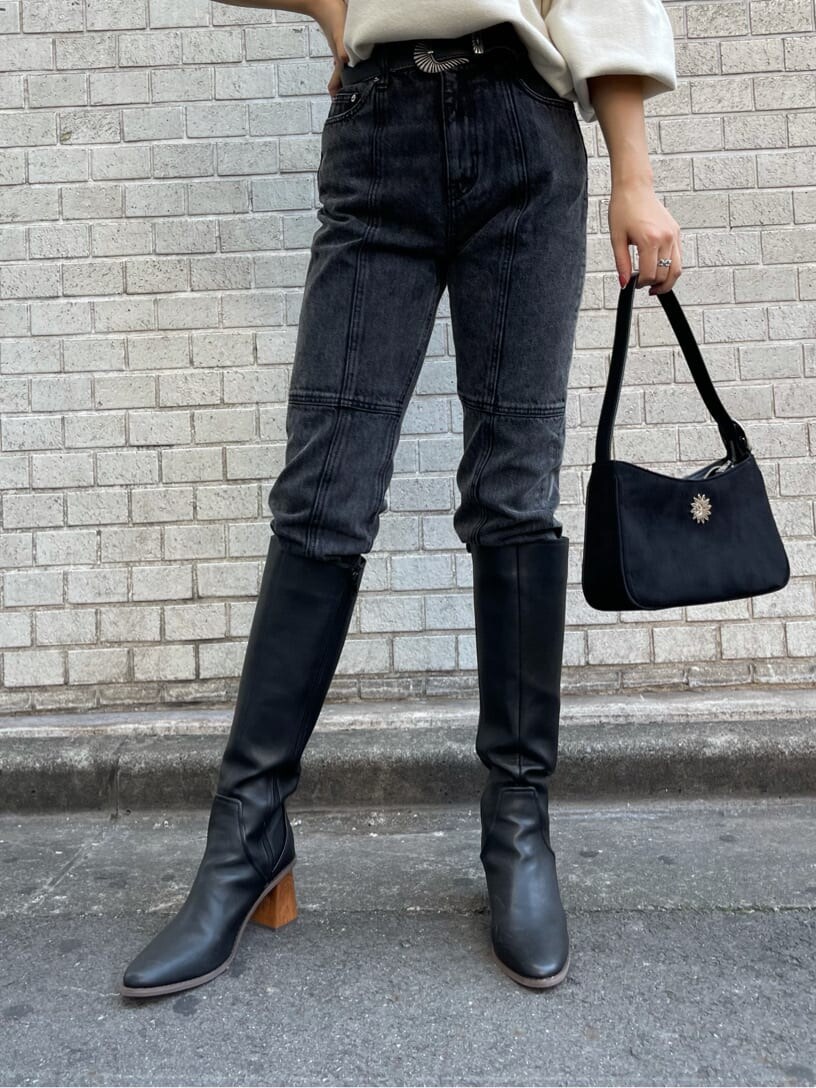 ブラック系のショルダーバッグ、ブラック系のデニムパンツ、ホワイト系のニット/セーターを着用したレディースの秋コーディネートの7枚目の写真