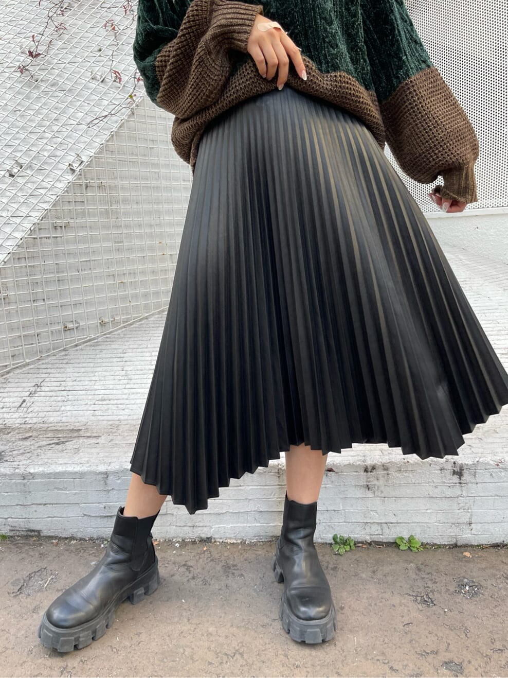 ブラック系のブーツ、ホワイト系のニット/セーター、ブラック系のスカートを着用したレディースの秋コーディネートの7枚目の写真