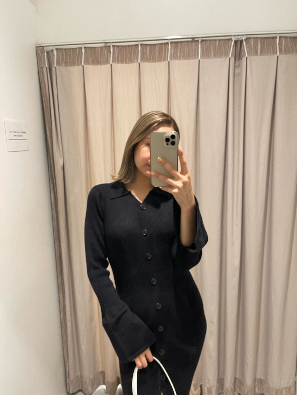 ホワイト系のブーツ、ブラック系のハンドバッグ、ブラック系のワンピースを着用したレディースの冬コーディネートの3枚目の写真