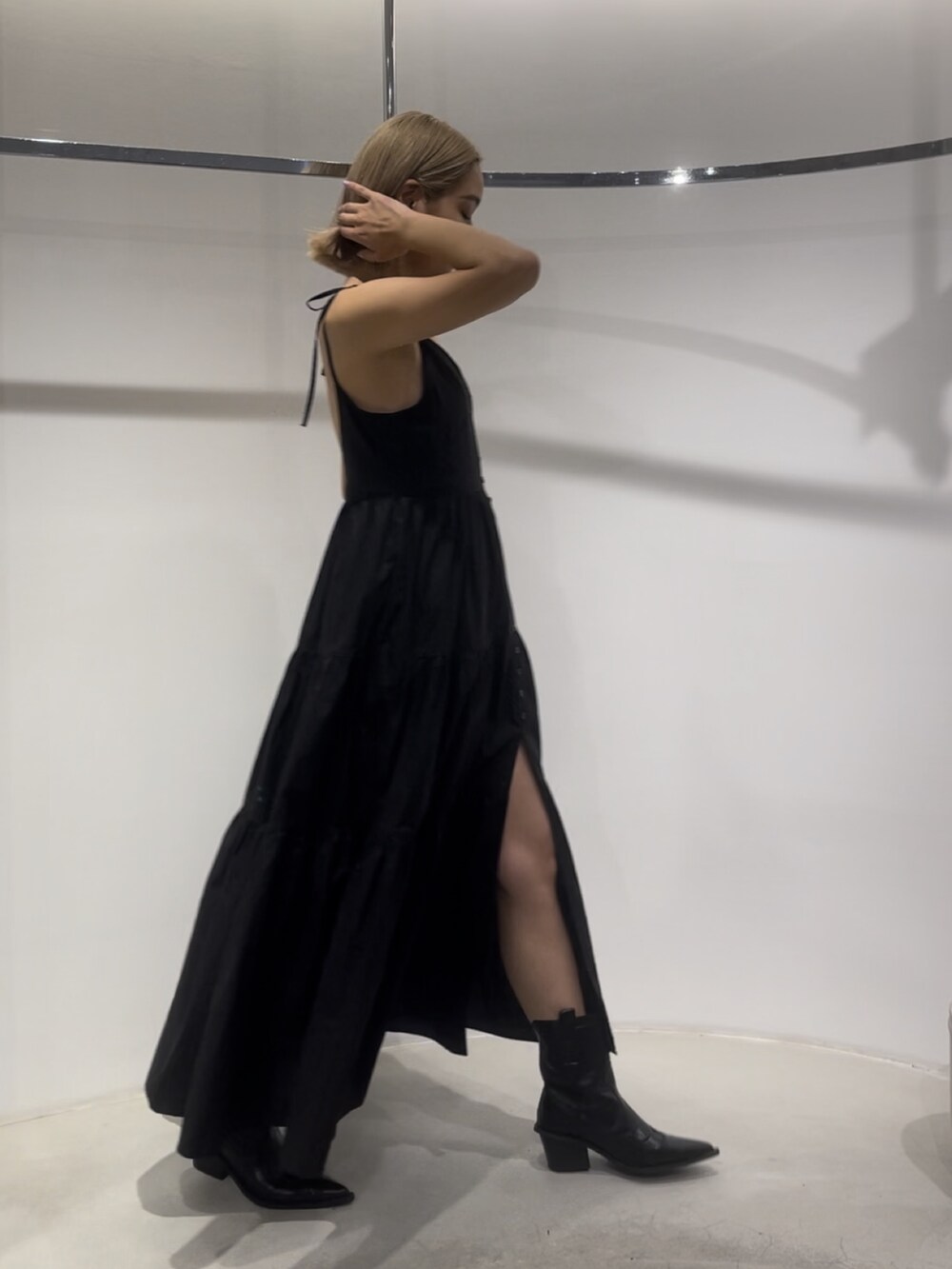 ブラック系のワンピース、ブラック系のブーツを着用したレディースの夏コーディネートの3枚目の写真