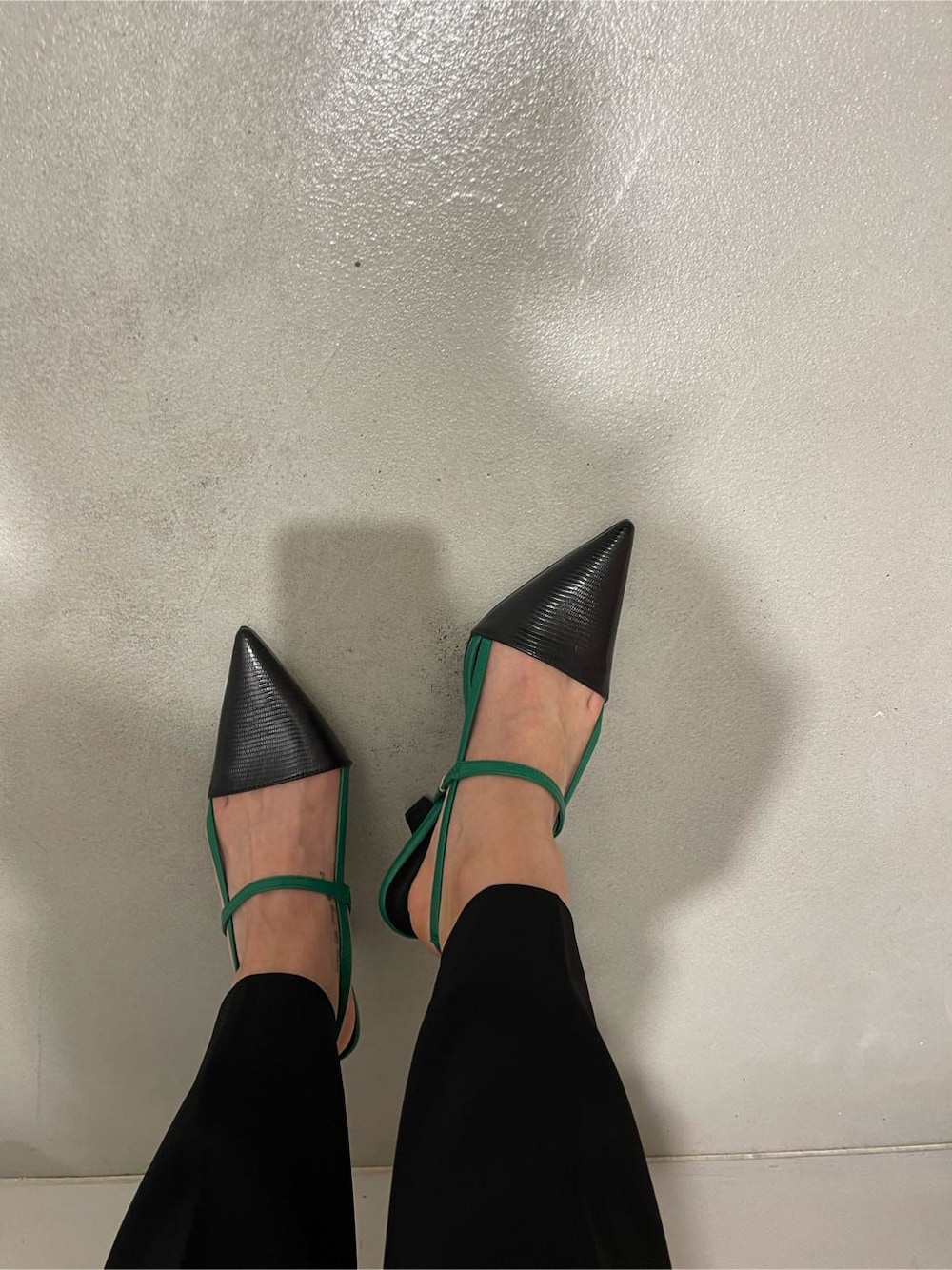 ブラック系のスラックス、ブラック系のワンピース、ホワイト系のショルダーバッグを着用したレディースの春コーディネートの8枚目の写真