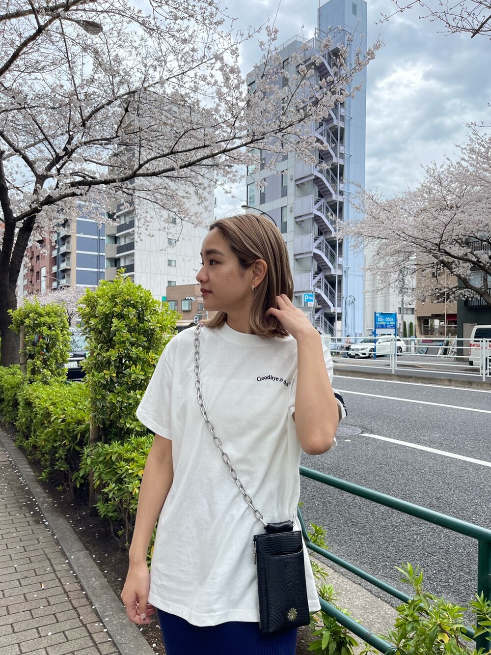 ブラック系のショルダーバッグ、ホワイト系のTシャツ/カットソー、ブルー系のスカートを着用したレディースの春コーディネートの5枚目の写真