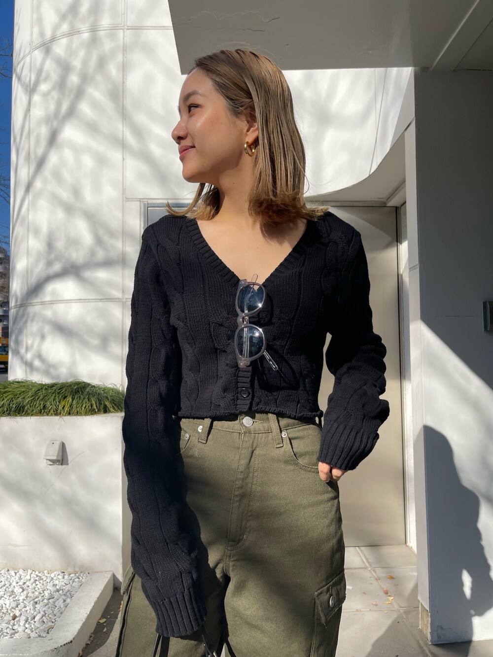 ブラック系のカーディガン/ボレロ、ブラック系のショルダーバッグ、ホワイト系のブーツを着用したレディースの冬コーディネートの6枚目の写真