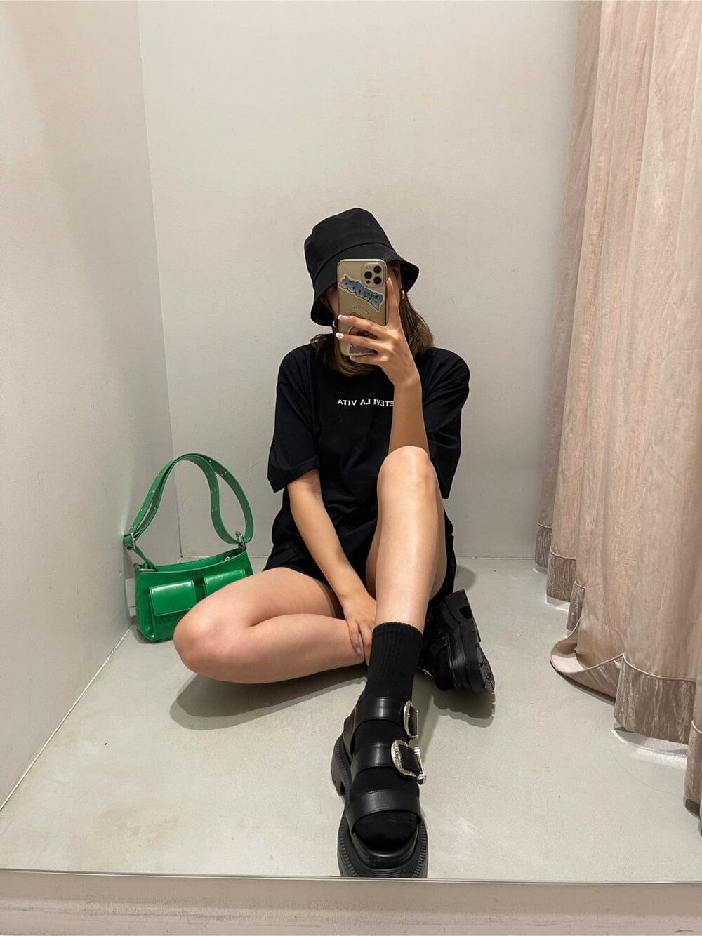 グリーン系のショルダーバッグ、ブラック系のサンダル、ブラック系のTシャツ/カットソーを着用したレディースの春コーディネートの3枚目の写真