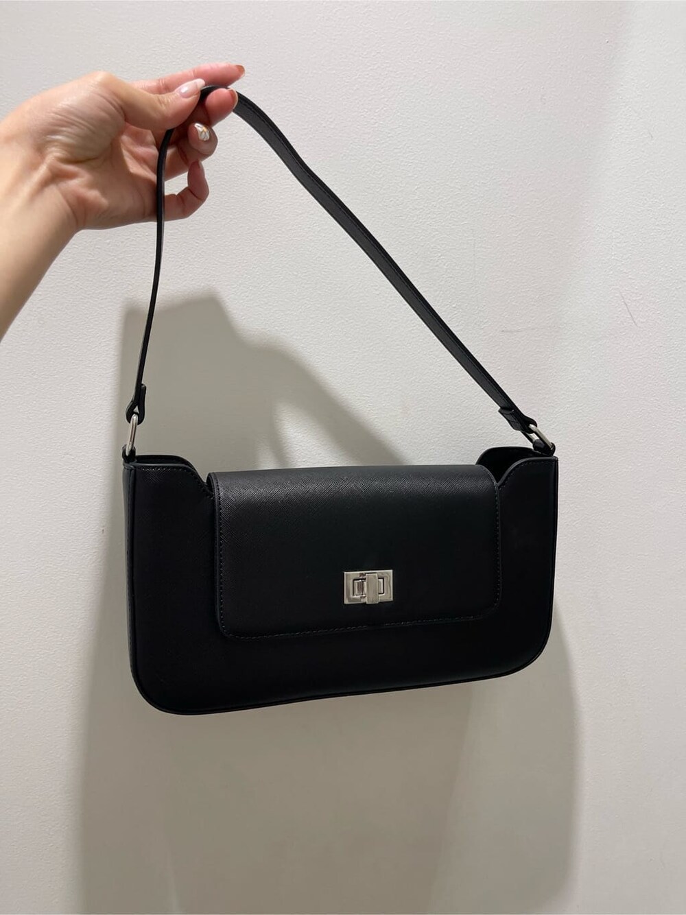 ブラック系のショルダーバッグ、ホワイト系のTシャツ/カットソー、ブラック系のスカートを着用したレディースの春コーディネートの8枚目の写真