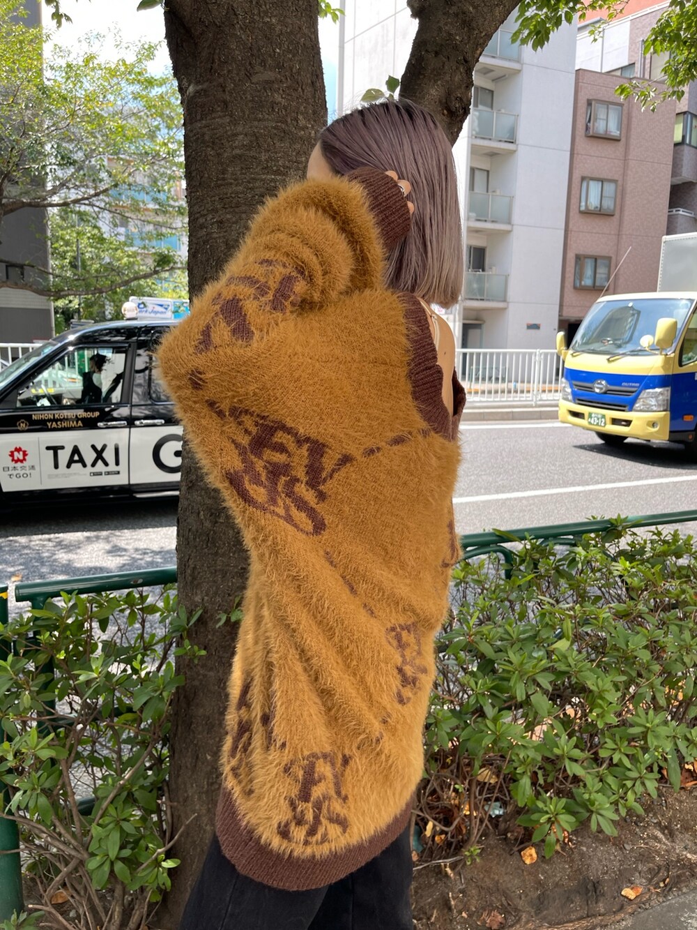 ブラック系のデニムパンツ、ブラウン系のカーディガン/ボレロ、ゴールド系のピアス（両耳用）を着用したレディースの秋コーディネートの6枚目の写真