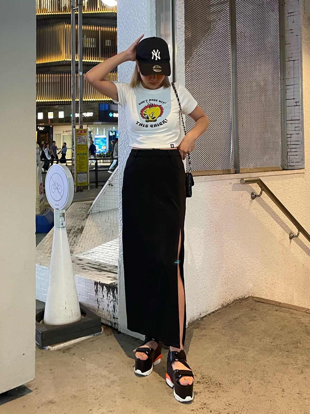 ホワイト系のTシャツ/カットソー、ブラック系のスカート、ブラック系のショルダーバッグを着用したレディースの夏コーディネートの2枚目の写真