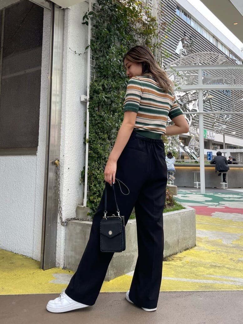 ブラック系のショルダーバッグ、グリーン系のニット/セーター、ブラック系のスラックスを着用したレディースの春コーディネートの3枚目の写真