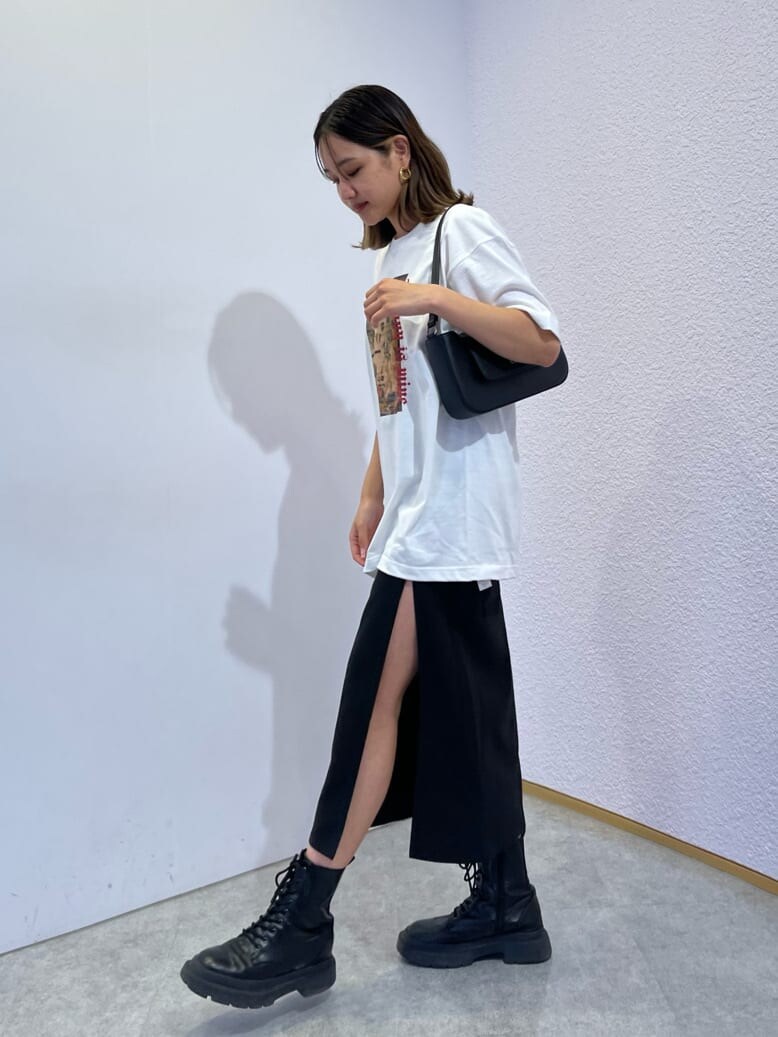 ブラック系のスカート、ブラック系のブーツ、ブラック系のショルダーバッグを着用したレディースの夏コーディネートの4枚目の写真