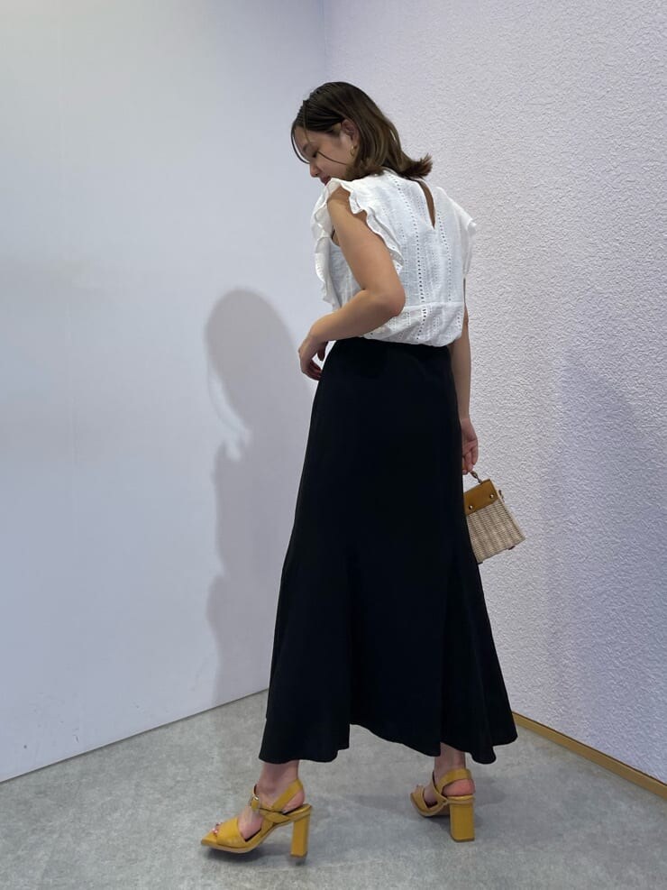 イエロー系のサンダル、ホワイト系のタンクトップ、ベージュ系のショルダーバッグを着用したレディースの夏コーディネートの3枚目の写真