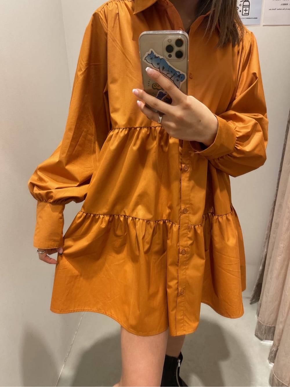 オレンジ系のシャツワンピース、ブラック系のブーツ、ブラック系のショルダーバッグを着用したレディースの冬コーディネートの5枚目の写真