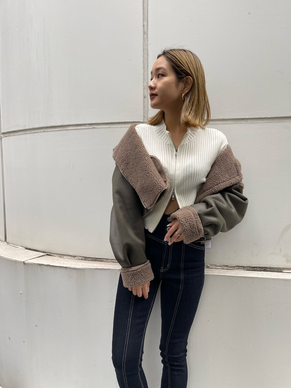 ブラック系のブーツ、ホワイト系のニット/セーター、グリーン系のブルゾンを着用したレディースの秋コーディネートの7枚目の写真