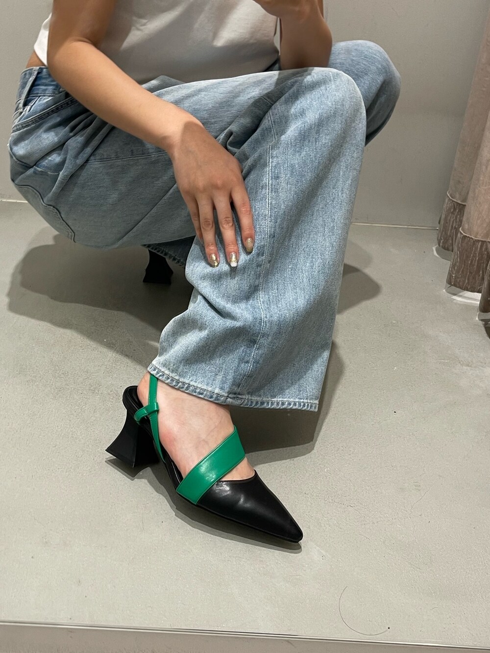 ブルー系のデニムパンツ、ブラック系のサンダル、ブルー系のTシャツ/カットソーを着用したレディースの春コーディネートの8枚目の写真