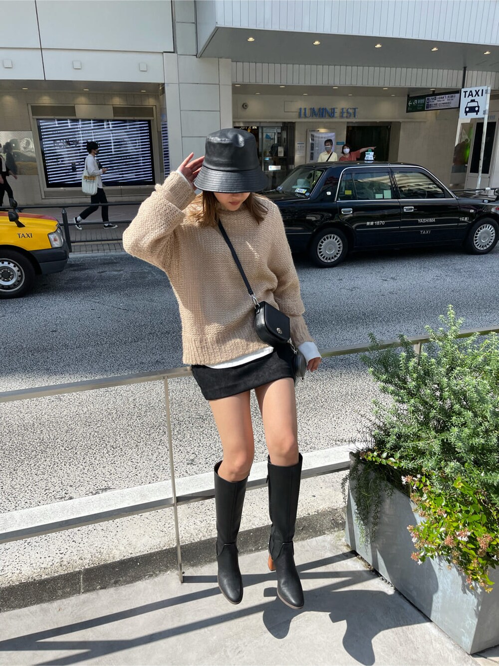 ブラック系のショルダーバッグ、ブラック系のブーツ、その他のニット/セーターを着用したレディースの秋コーディネートの2枚目の写真