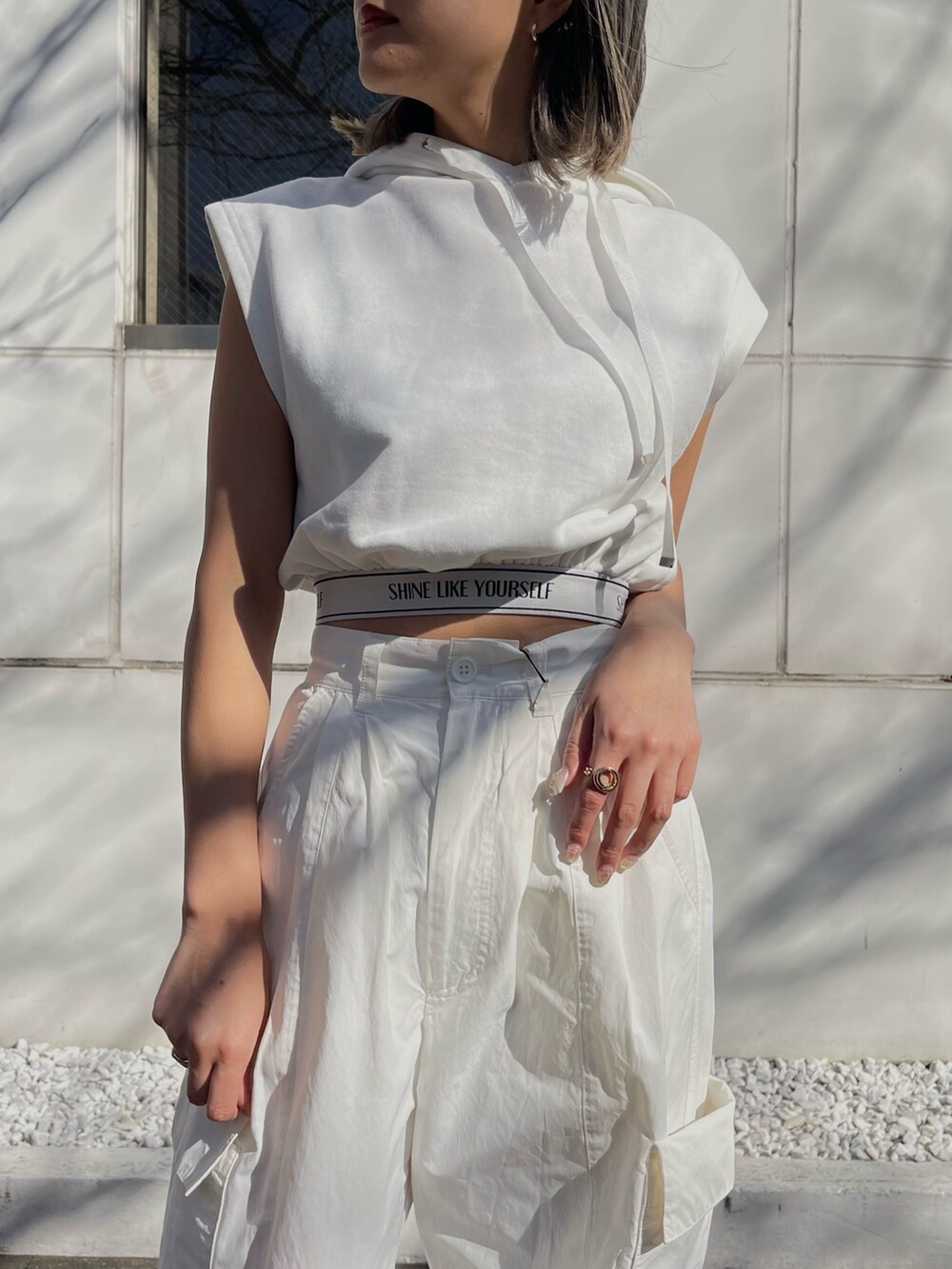 ホワイト系のブーツ、ホワイト系のカーゴパンツ、ブラック系のショルダーバッグを着用したレディースの春コーディネートの7枚目の写真