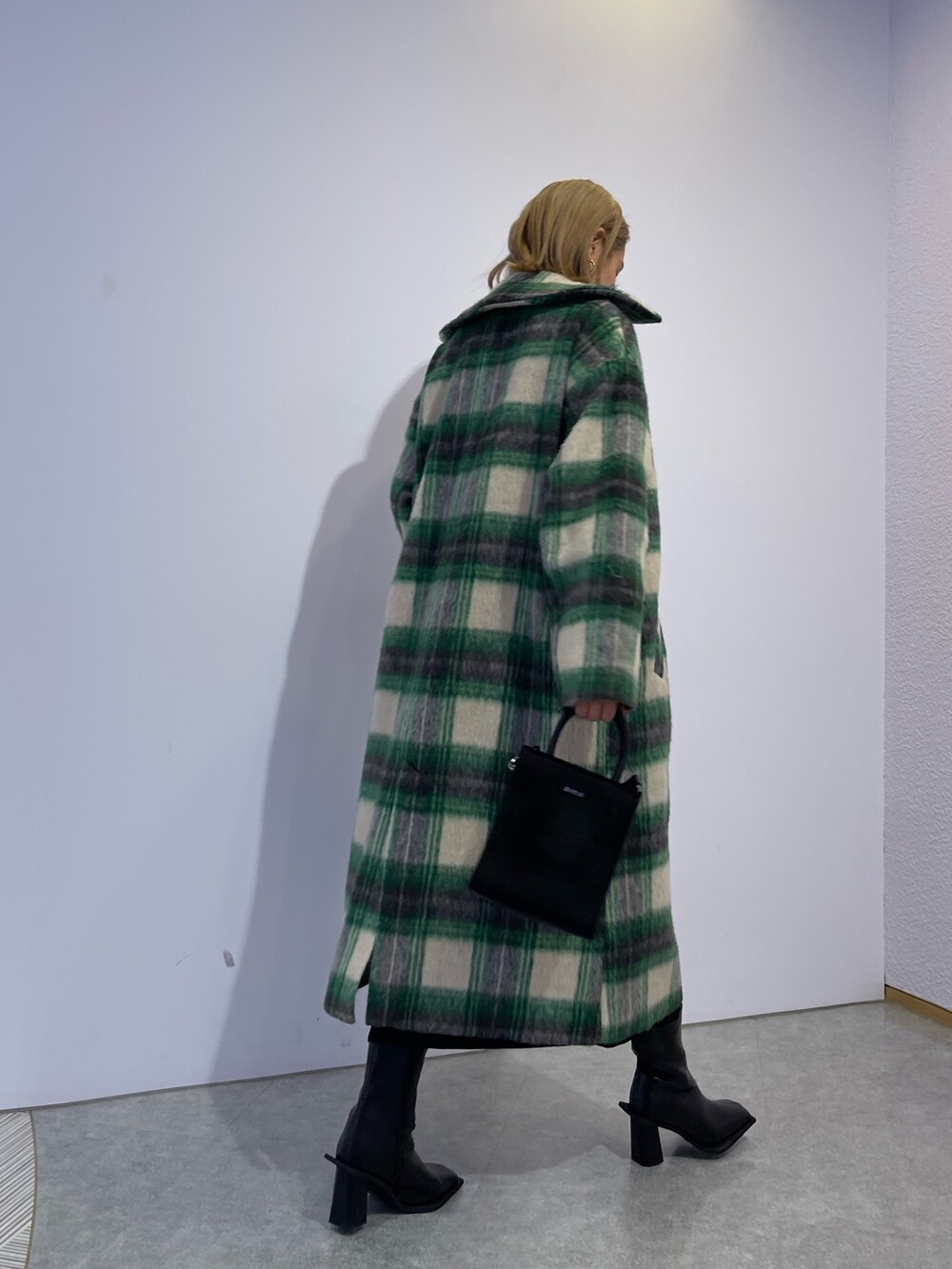 グリーン系のその他アウター、ブラック系のブーツ、ブラック系のワンピースを着用したレディースの冬コーディネートの4枚目の写真