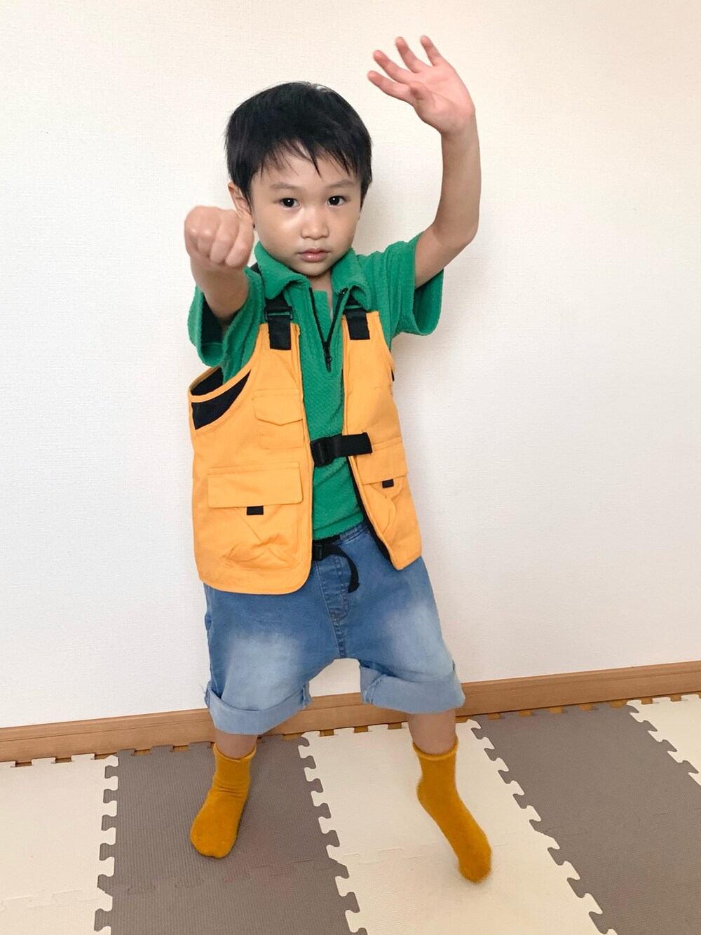 グリーン系のパンツ、オレンジ系のベスト、ブルー系のデニムパンツを着用したキッズの秋コーディネートの5枚目の写真