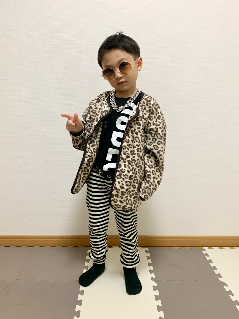 ベージュ系のカーディガン/ボレロ、ホワイト系のパンツ、ブラック系のTシャツ/カットソーを着用したキッズの冬コーディネートの4枚目の写真