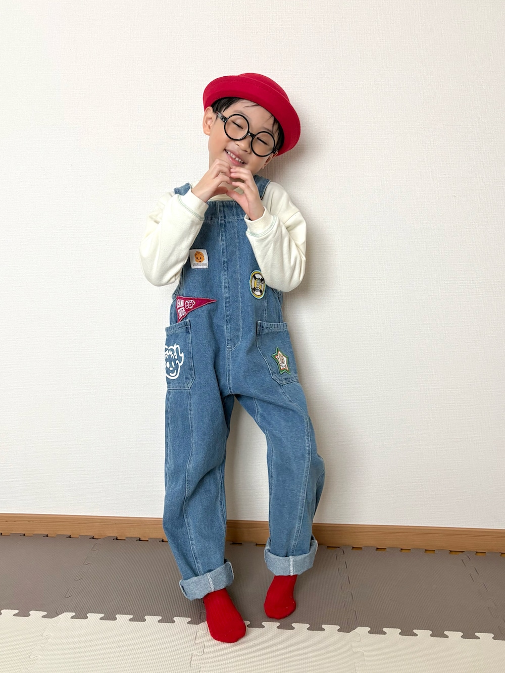 ブルー系のサロペット/オーバーオール、レッド系のハット、ホワイト系のその他を着用したキッズの春コーディネートの2枚目の写真