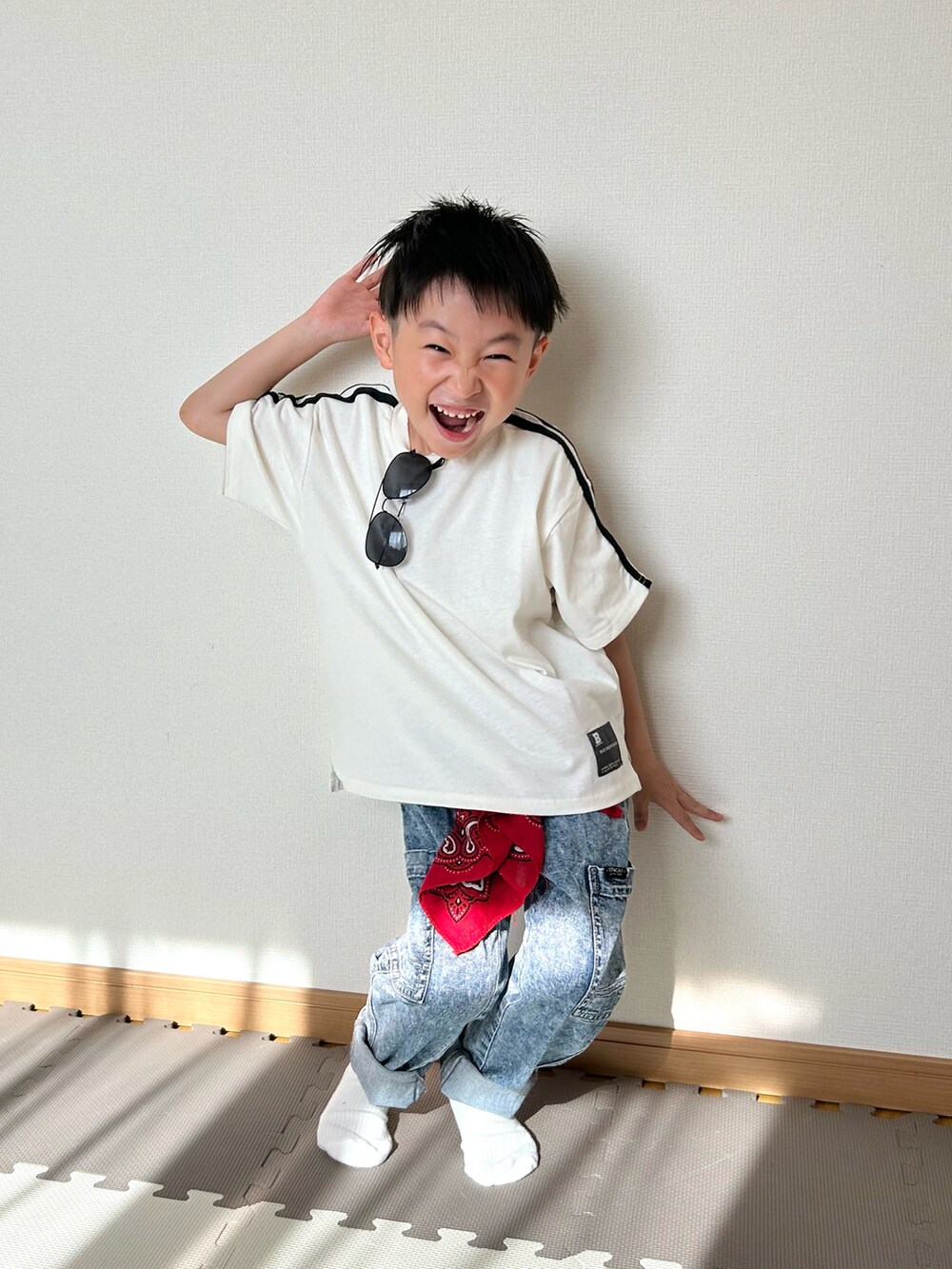 ホワイト系のTシャツ/カットソー、ブルー系のパンツ、レッド系のストール/ショールを着用したキッズの春コーディネートの5枚目の写真