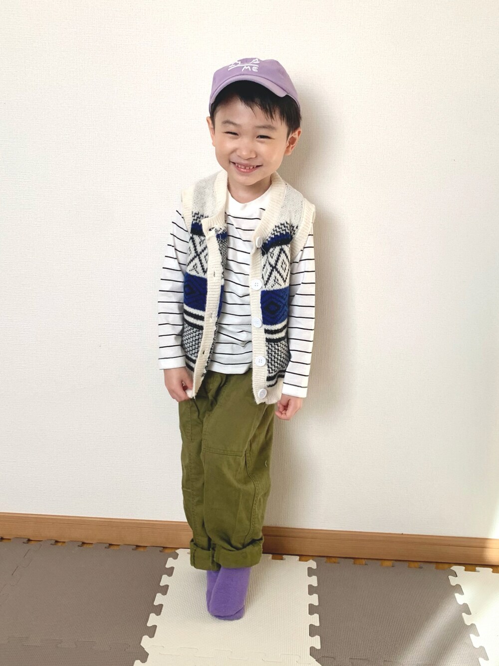 ホワイト系のベスト、ホワイト系のTシャツ/カットソー、グリーン系のパンツを着用したキッズの冬コーディネートの3枚目の写真