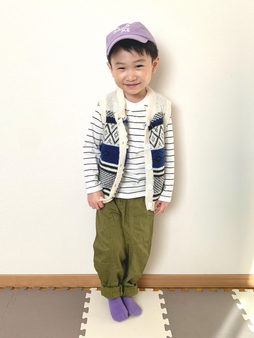 ホワイト系のベスト、ホワイト系のTシャツ/カットソー、グリーン系のパンツを着用したキッズの冬コーディネートの2枚目の写真