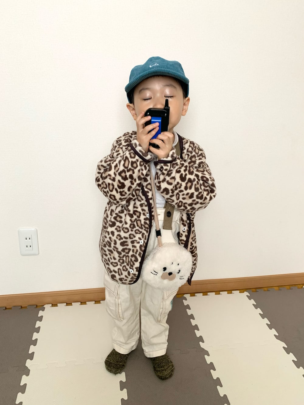 ベージュ系のカーディガン/ボレロ、ホワイト系のTシャツ/カットソー、ホワイト系のサロペット/オーバーオールを着用したキッズの冬コーディネートの5枚目の写真