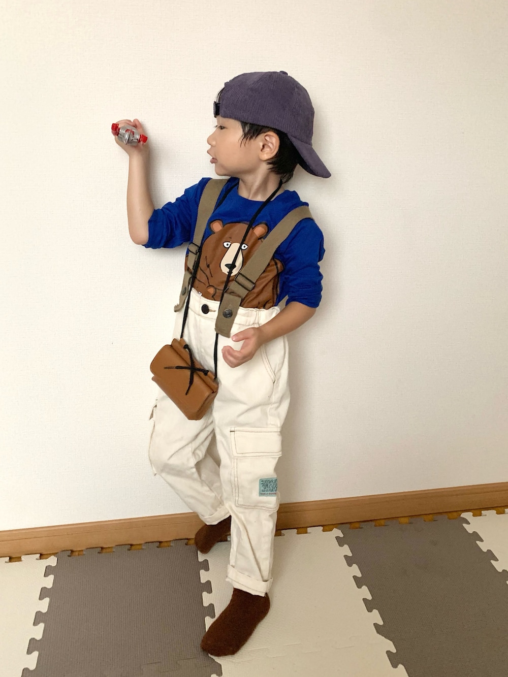 ホワイト系のサロペット/オーバーオール、グリーン系のTシャツ/カットソー、ブラウン系のショルダーバッグを着用したキッズの秋コーディネートの4枚目の写真