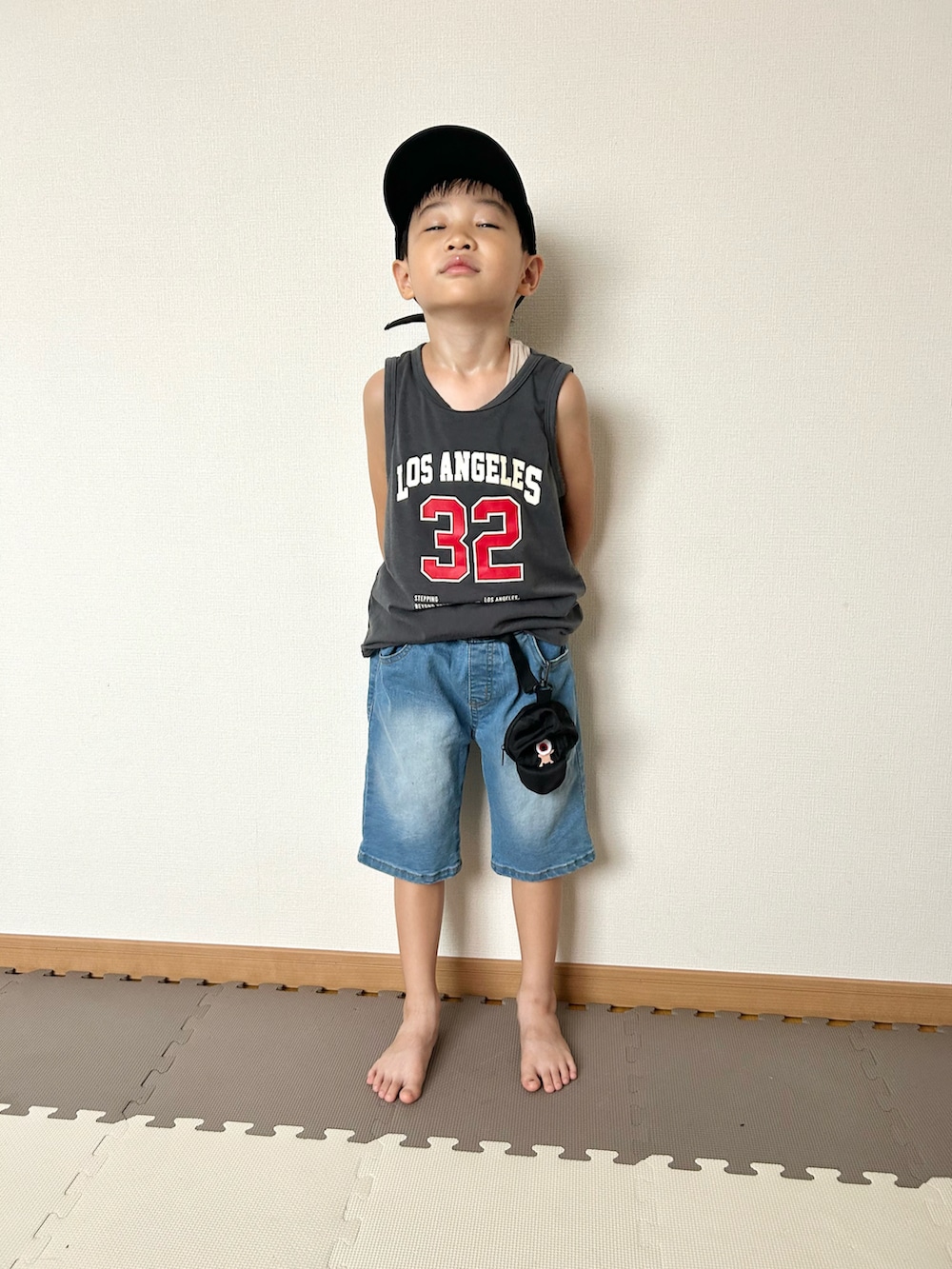 ブルー系のデニムパンツ、グレー系のタンクトップ、ブラック系のバッグを着用したキッズの夏コーディネートの2枚目の写真