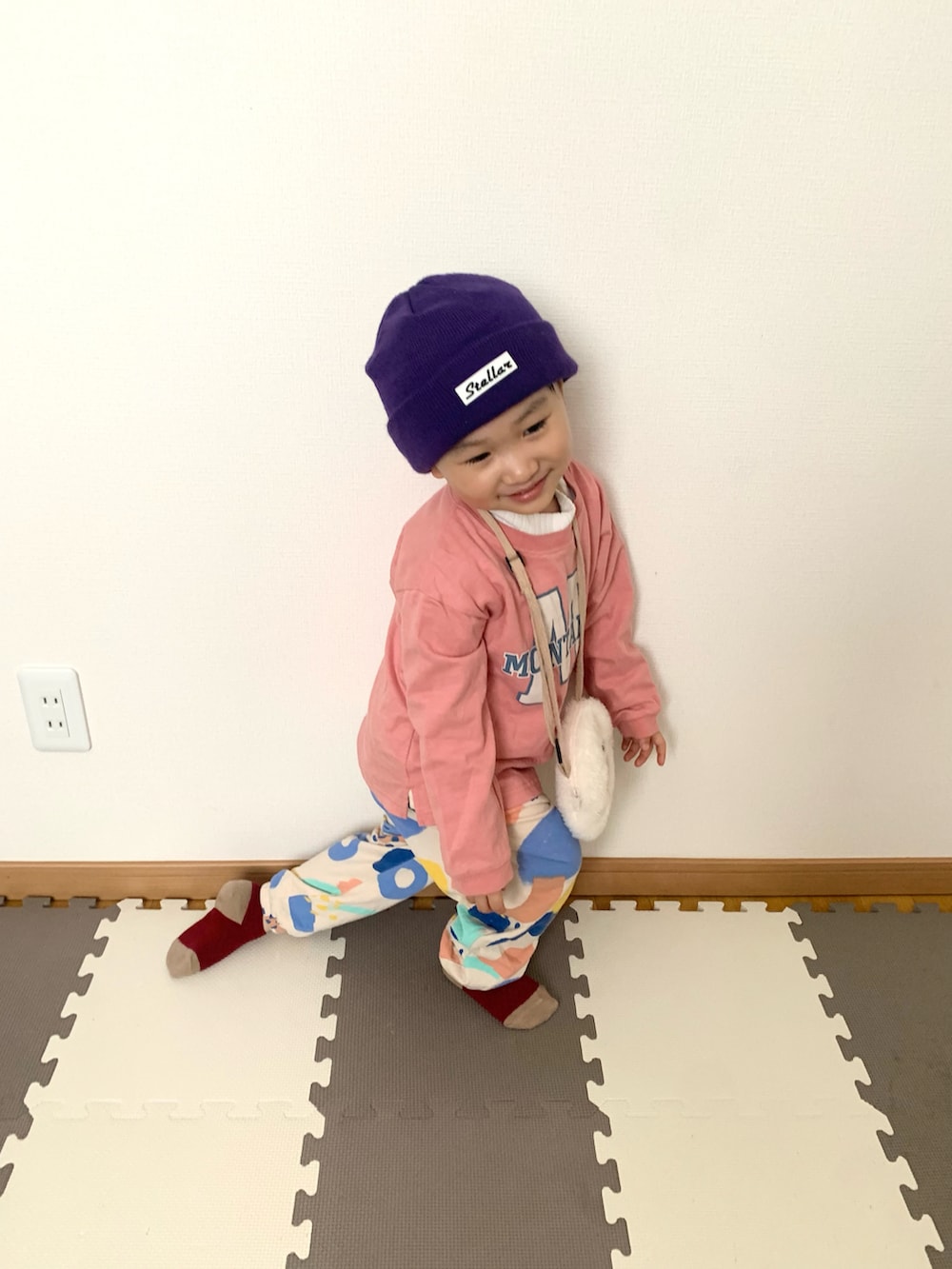 ピンク系のTシャツ/カットソー、その他のスウェットパンツ、ホワイト系のショルダーバッグを着用したキッズの冬コーディネートの2枚目の写真