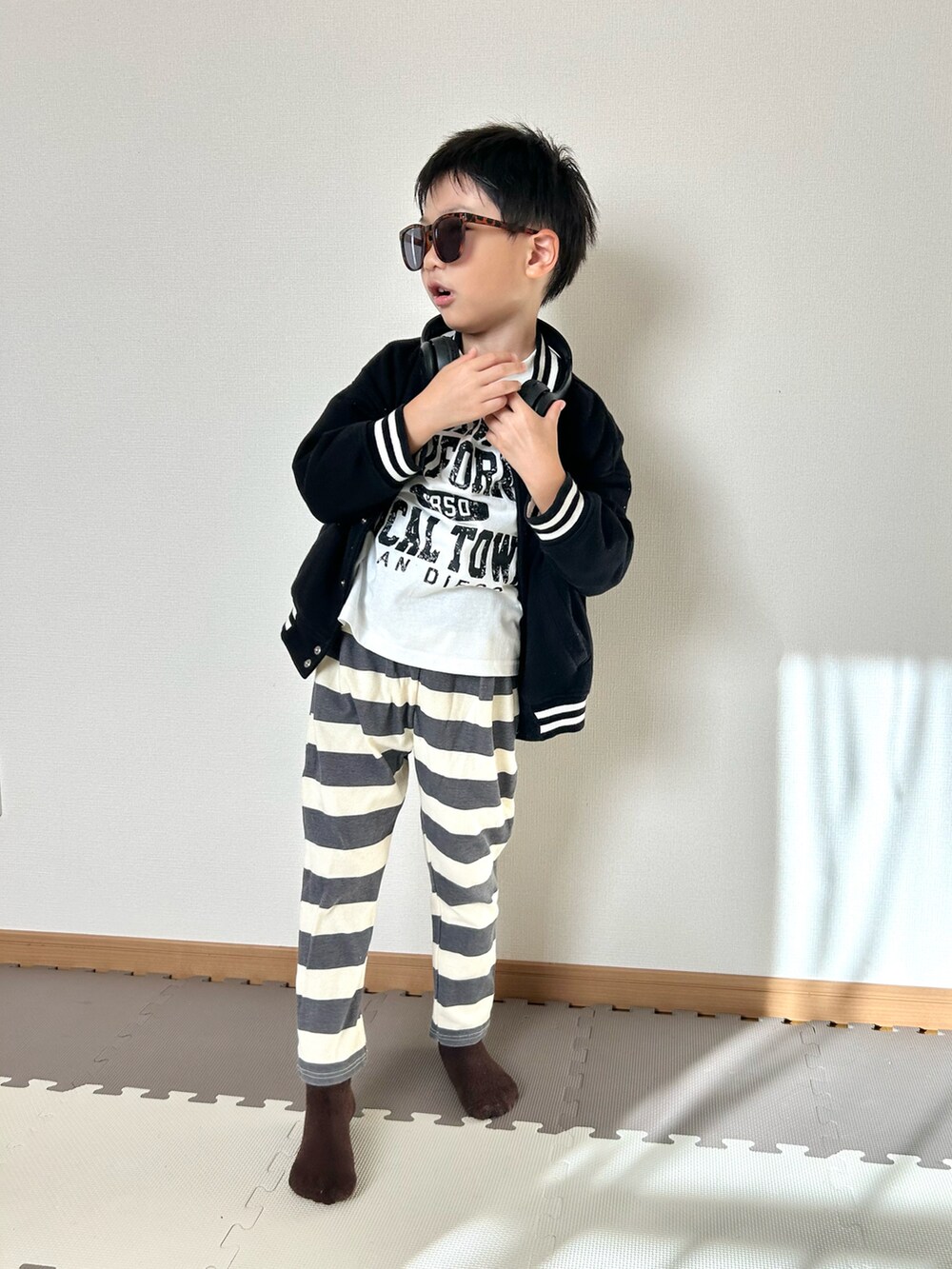 グレー系のその他パンツ、ホワイト系のTシャツ/カットソー、ブラック系のジャケット/アウターを着用したキッズの秋コーディネートの2枚目の写真