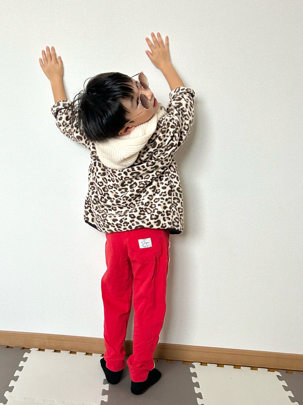 レッド系のスウェットパンツ、ベージュ系のカーディガン/ボレロ、ホワイト系のTシャツ/カットソーを着用したキッズの秋コーディネートの3枚目の写真