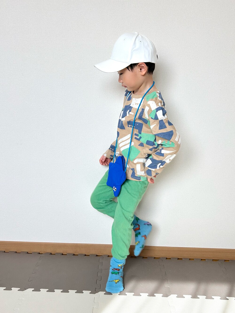 ベージュ系のTシャツ/カットソー、グリーン系のスウェットパンツ、ブルー系のショルダーバッグを着用したキッズの春コーディネートの2枚目の写真