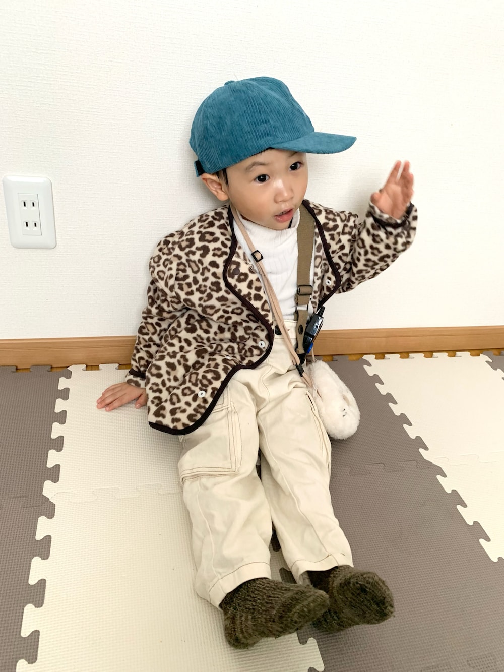 ベージュ系のカーディガン/ボレロ、ホワイト系のTシャツ/カットソー、ホワイト系のサロペット/オーバーオールを着用したキッズの冬コーディネートの2枚目の写真