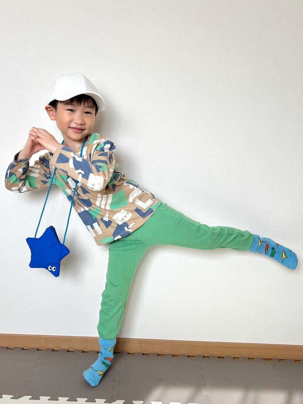 ベージュ系のTシャツ/カットソー、グリーン系のスウェットパンツ、ブルー系のショルダーバッグを着用したキッズの春コーディネートの4枚目の写真