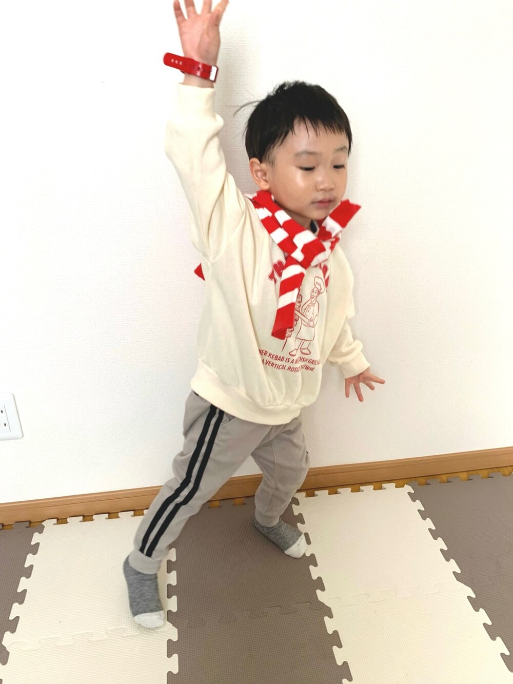 ホワイト系のスウェット、グレー系のその他パンツ、レッド系のカーディガン/ボレロを着用したキッズの冬コーディネートの3枚目の写真