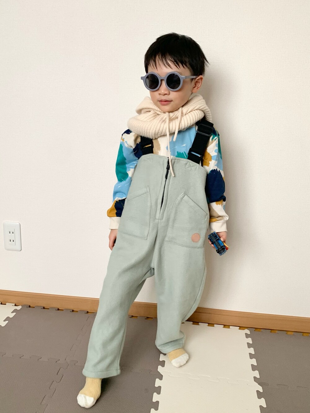 グリーン系のサロペット/オーバーオール、その他のスウェット、ホワイト系のネックウォーマー/スヌードを着用したキッズの冬コーディネートの5枚目の写真