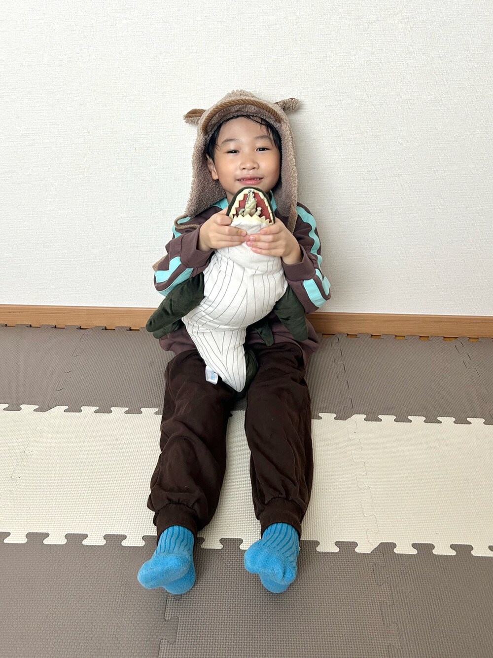 ブラウン系のスウェット、ブラウン系のスウェットパンツ、ブラウン系の帽子を着用したキッズの冬コーディネートの5枚目の写真