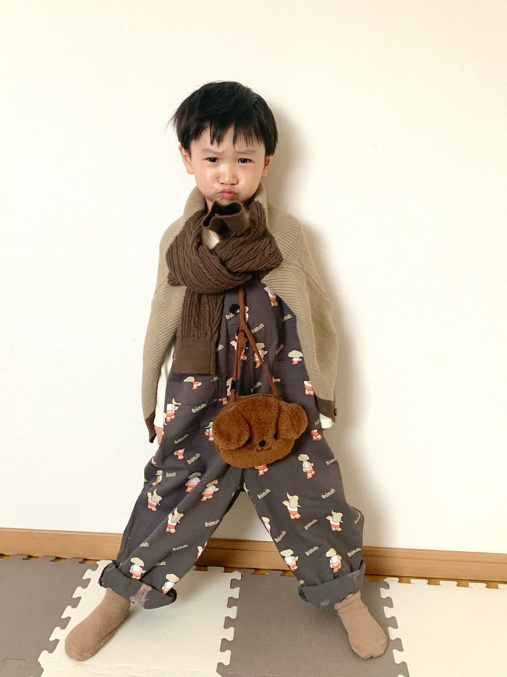ブラウン系のショルダーバッグ、グレー系のサロペット/オーバーオール、ブラウン系のカーディガン/ボレロを着用したキッズの秋コーディネートの2枚目の写真
