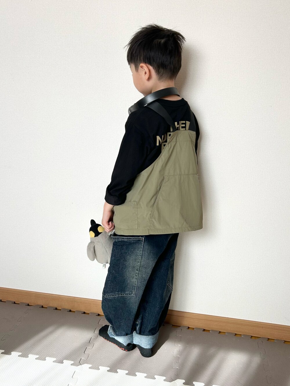 グリーン系のダウンベスト、ブラック系のTシャツ/カットソー、ブラック系のヘッドフォン/イヤホンを着用したキッズの春コーディネートの5枚目の写真