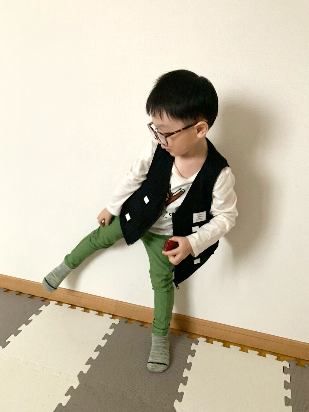 ブラック系のベスト、グリーン系のその他パンツ、ホワイト系のTシャツ/カットソーを着用したキッズの春コーディネートの3枚目の写真