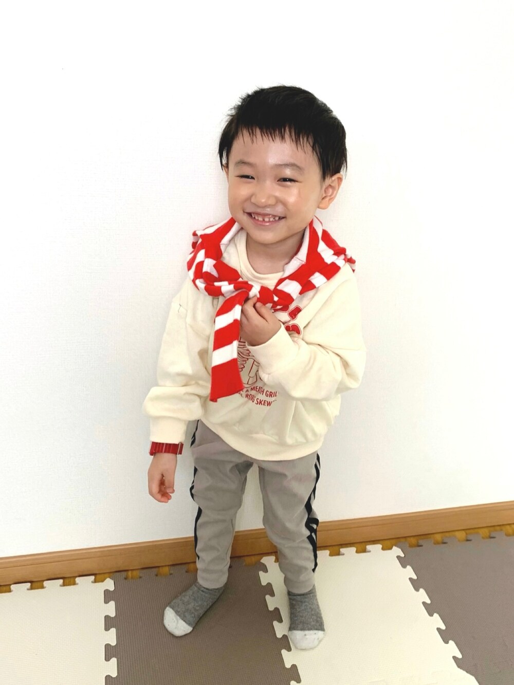 ホワイト系のスウェット、グレー系のその他パンツ、レッド系のカーディガン/ボレロを着用したキッズの冬コーディネートの2枚目の写真