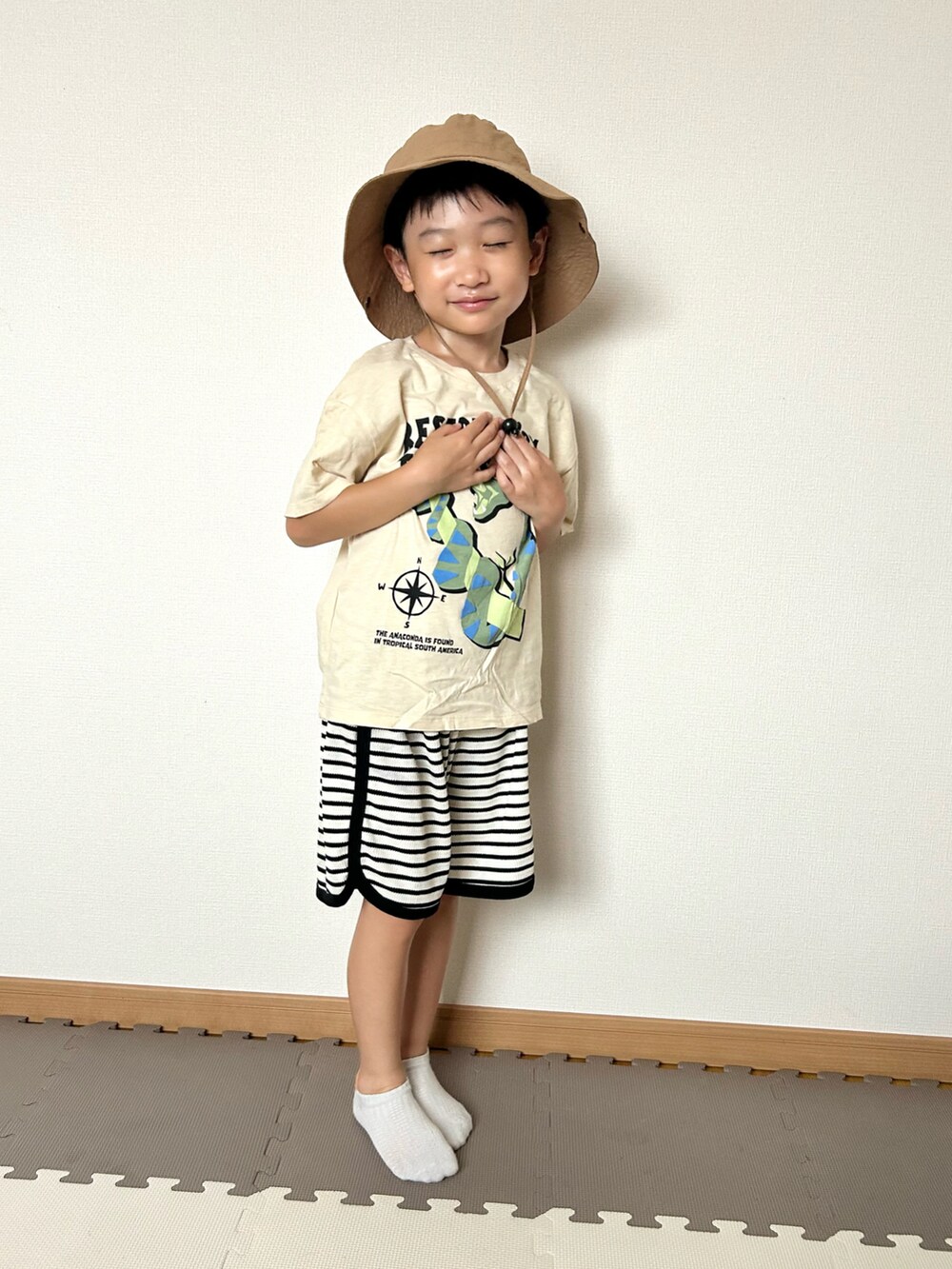 ホワイト系のセットアップ、ベージュ系のTシャツ/カットソー、オレンジ系のソックス/靴下を着用したキッズの夏コーディネートの5枚目の写真