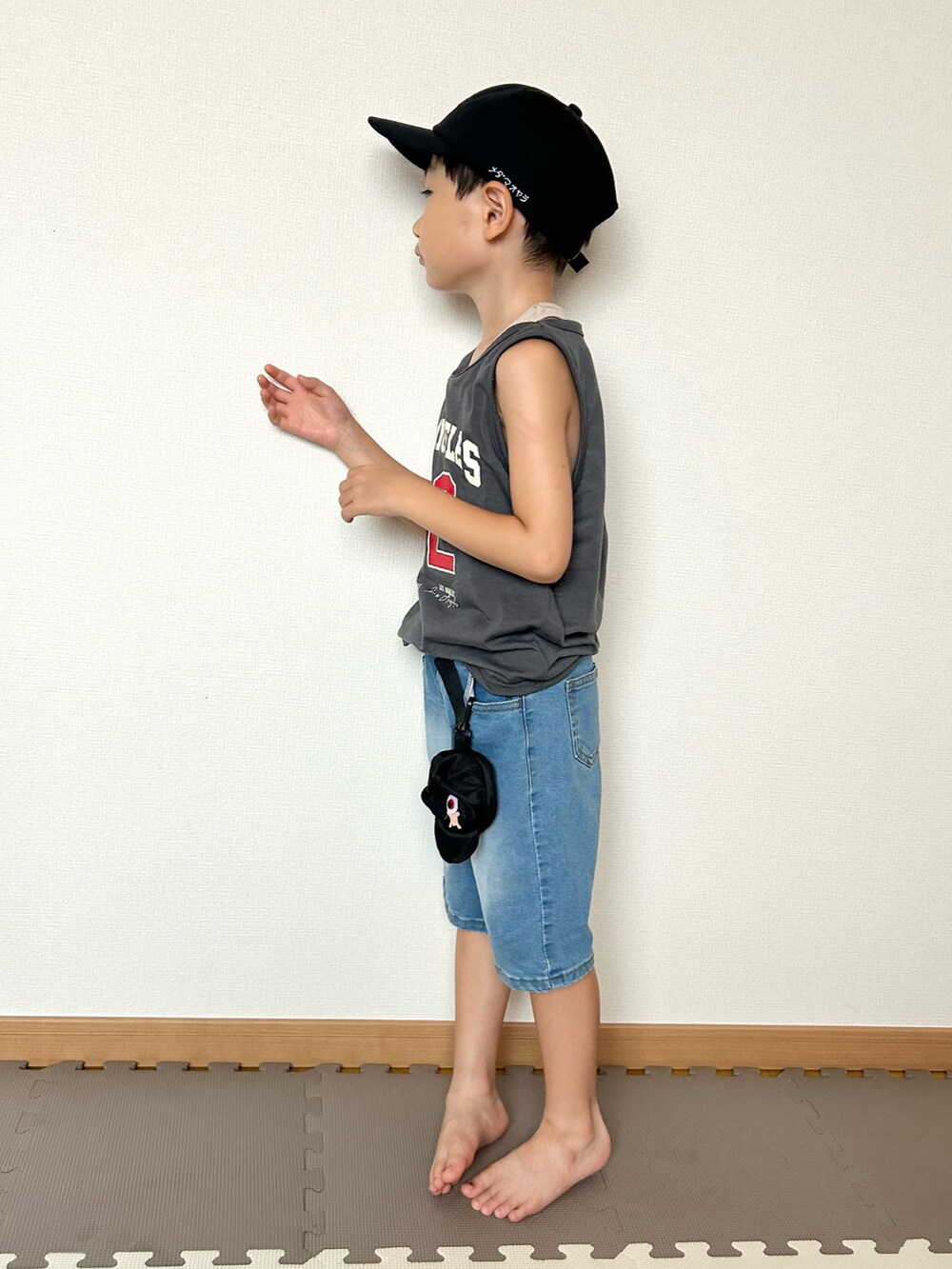 ブルー系のデニムパンツ、グレー系のタンクトップ、ブラック系のバッグを着用したキッズの夏コーディネートの5枚目の写真