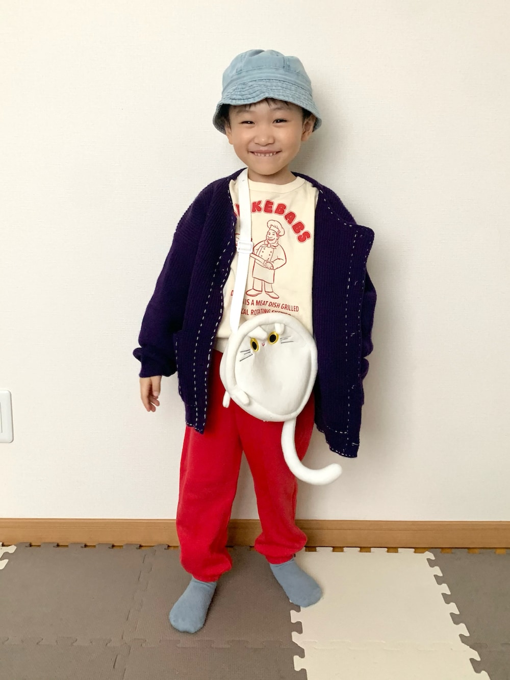 レッド系のその他パンツ、パープル系のカーディガン/ボレロ、ホワイト系のスウェットを着用したキッズの冬コーディネートの2枚目の写真