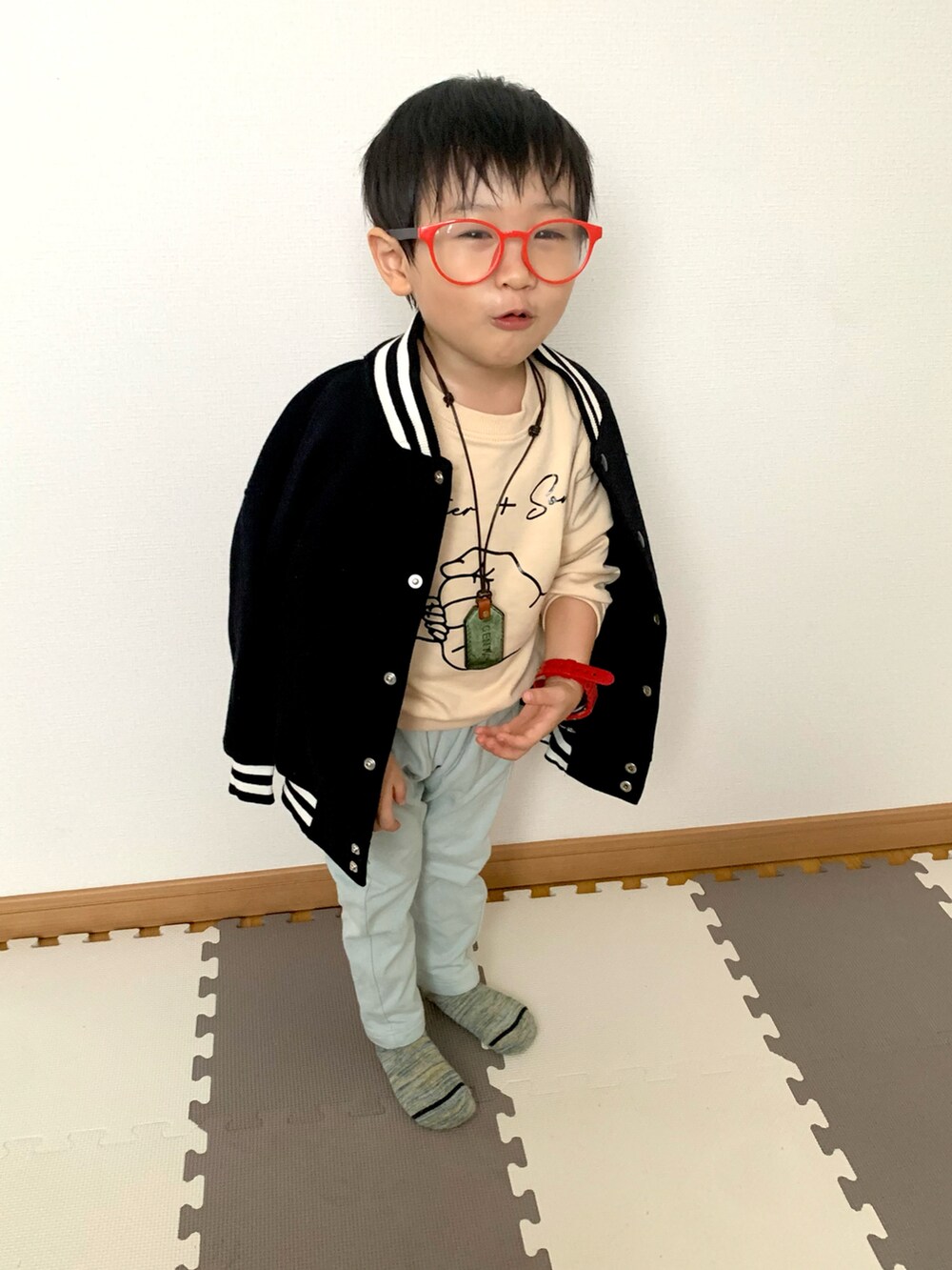 グリーン系のスウェットパンツ、ブラック系のブルゾン、ベージュ系のスウェットを着用したキッズの冬コーディネートの2枚目の写真