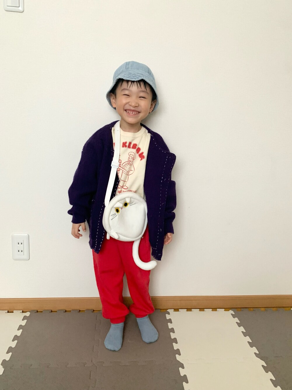 レッド系のその他パンツ、パープル系のカーディガン/ボレロ、ホワイト系のスウェットを着用したキッズの冬コーディネートの4枚目の写真