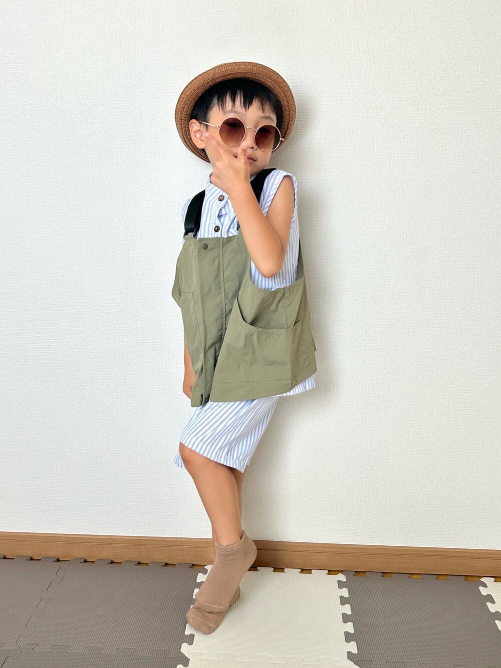 グリーン系のダウンベスト、ブルー系のシャツ/ブラウス、ブルー系のその他パンツを着用したキッズの夏コーディネートの2枚目の写真