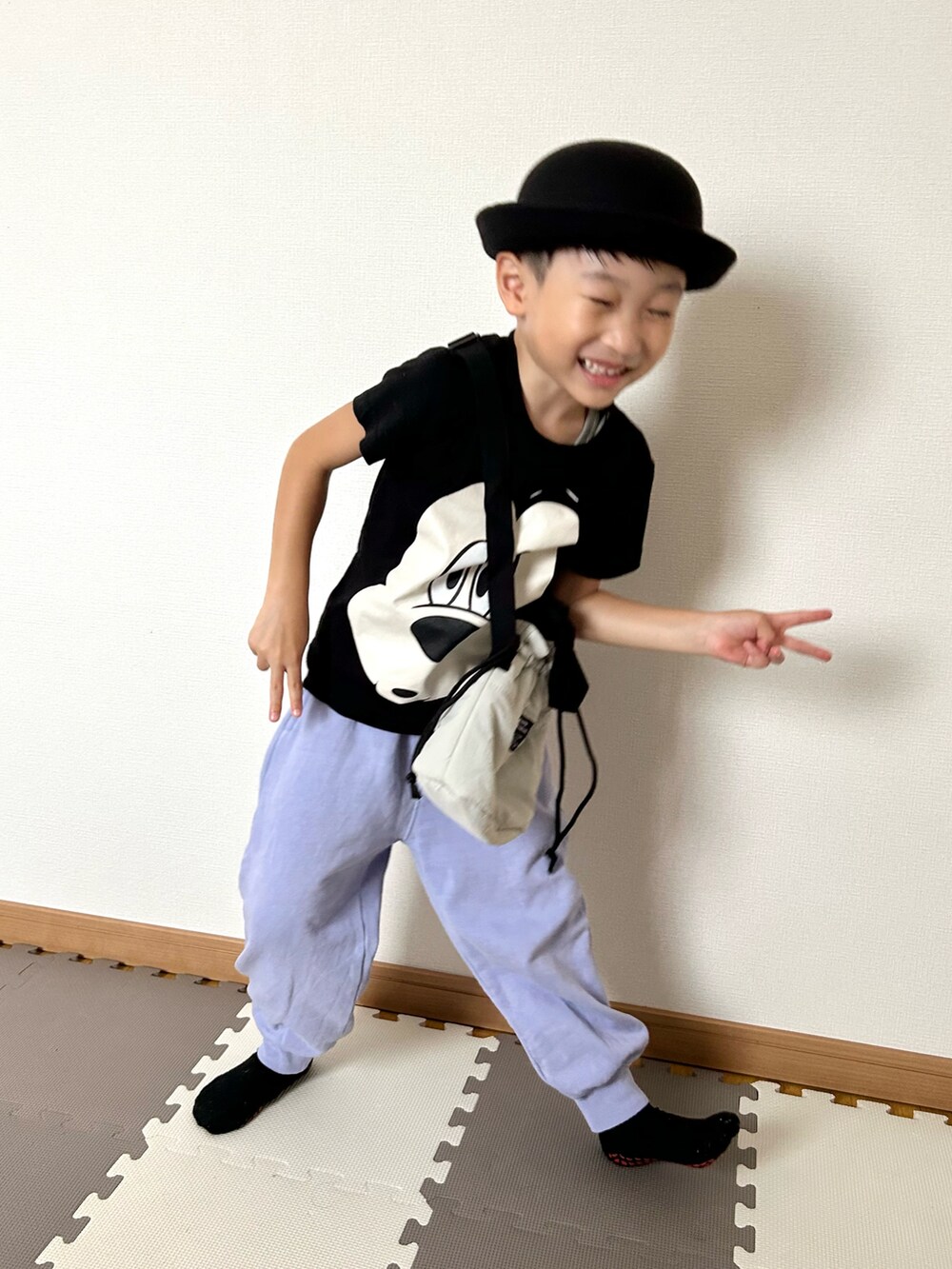 グレー系のショルダーバッグ、パープル系のスウェットパンツ、ブラック系のTシャツ/カットソーを着用したキッズの秋コーディネートの3枚目の写真