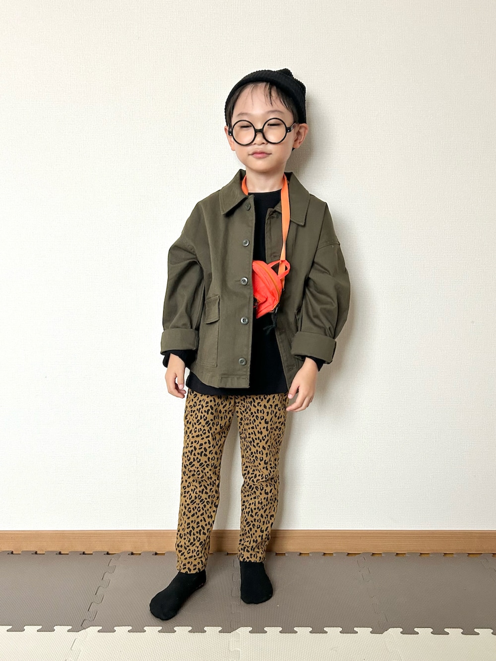 ブラック系のTシャツ/カットソー、グリーン系のジャケット/アウター、ブラウン系のパンツを着用したキッズの秋コーディネートの5枚目の写真